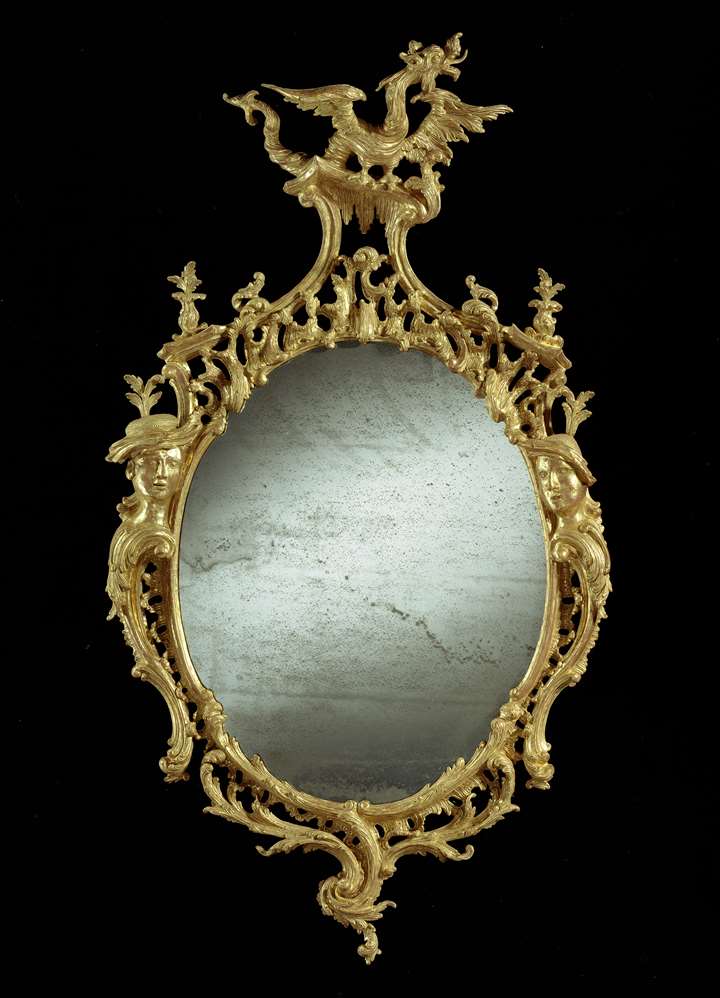 A oval giltwood mirror to a design by Thomas Johnson